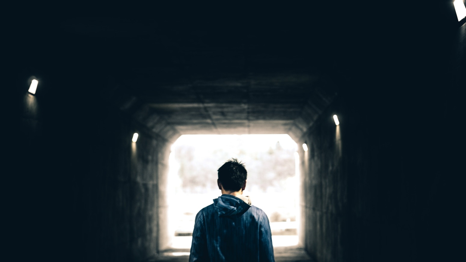 Ungdom som går inn i en mørk tunnel